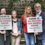 Ricky Gervais with wife Jane Fallon and Peter Egan holding bespoke protest placards for animal rights